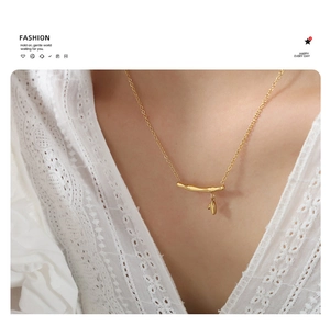 Gros plan d'un collier pendentif bambou doré de luxe sur une robe en dentelle