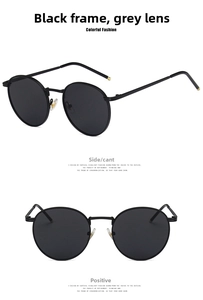 Detail view of vintage round black metal sunglasses with dark grey lenses and gold accents