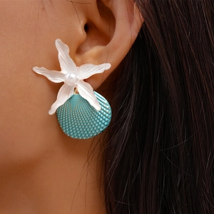 Close-up of beach style starfish and shell drop earrings with pearl on female model