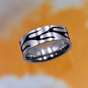 Macro detail of silver titanium steel ring featuring black flame patterns for punk rock style