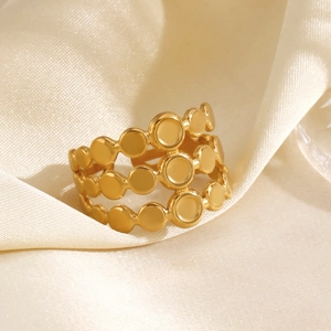Anello multistrato in acciaio inossidabile dorato minimalista su tessuto in raso champagne