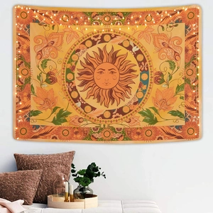 Detail of bohemian sun tapestry with flower and zodiac patterns and warm string lights