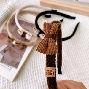 Macro detail of corduroy bow headband set with knitted fabric wrap and rabbit patch