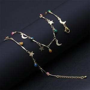 Macro detail of gold link necklace featuring colorful beads and star moon charms