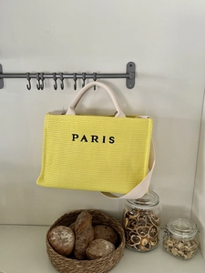 Detail of yellow woven tote bag with Paris embroidery and long shoulder straps