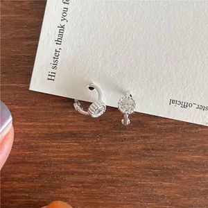 Detail of 925 sterling silver hoop earrings with round zircon on a vintage card