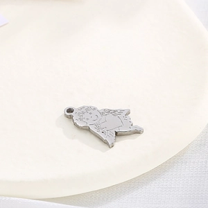 Polished silver stainless steel Cupid angel pendant on a minimalist beige round display