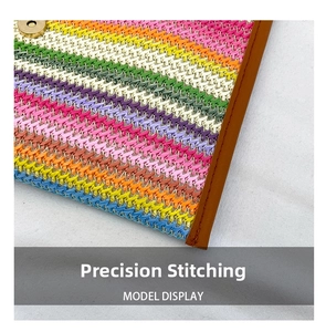Detail showing rainbow woven texture and brown leather trim on the envelope clutch bag
