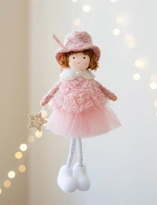 Detail of pink plush angel doll with golden star ornament and soft bokeh background