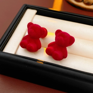 Macro shot of red flocked bear earrings placed in a premium jewelry gift box display