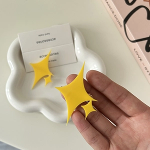Barrettes Kagura Hikari en forme d'étoile jaune présentées sur un plateau en céramique