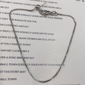 Detail of adjustable silver box chain bracelet with lobster clasp and slider bead
