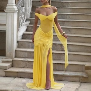 Detail of elegant yellow off-shoulder evening dress with high slit and flowing chiffon fabric