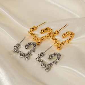 Lava texture heart hoop earrings in 18K gold and silver finish on white silk