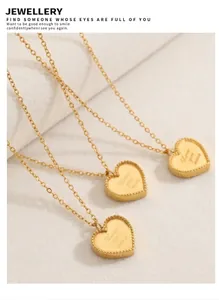 Vue détaillée de trois colliers cœur dorés gravés Love You More sur feutrine bleue