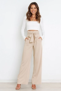 Detail of high-waisted wide-leg trousers with elegant matching bow tie-belt in beige