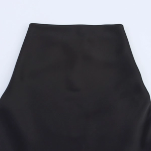 Detailed close-up view of the smooth matte waistline and seams on a black mini dress