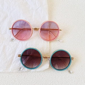 Fashionable round children sunglasses with pink and teal frames and gold metal details