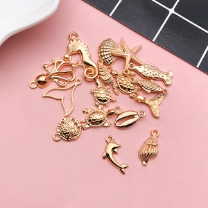 Macro shot of assorted gold sea animal charms including starfish, turtle, and seahorse