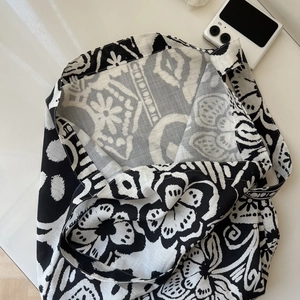 Top view of a bohemian cotton linen tote bag featuring black and white floral patterns