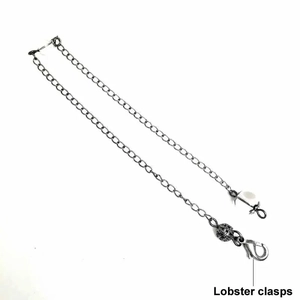 Detailansicht der Silberkette mit Karabinerverschlüssen und kleiner Hohlmetallkugel