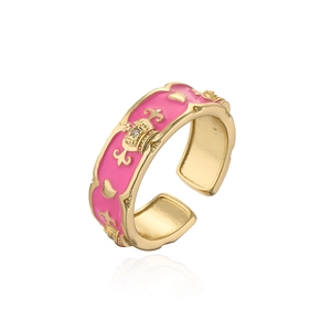 Detail of 18K gold plated crown ring with pink enamel and sparkling zircon stone