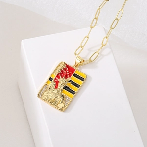 Gold plated Lady Liberty pendant necklace with enamel details on white cube prop