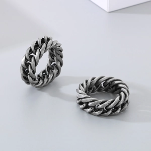Detail view of two vintage silver Cuban link chain rings in titanium steel finish