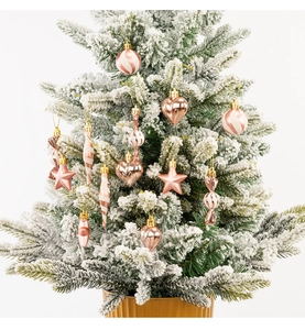 Close-up of rose gold Christmas tree ornaments with glitter finish on white tree