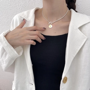 925 Sterling silver necklace with yellow smiley face pendant on model's neckline