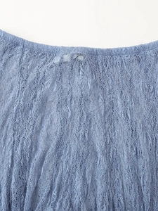 Gros plan détaillé du tissu en dentelle bleue montrant des motifs floraux et des textures