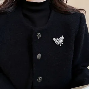 Elegant silver butterfly pearl brooch with rhinestones on black tweed jacket for women