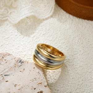 Macro detail of wave-shaped 18K gold and silver triple-layered textured ring on stone