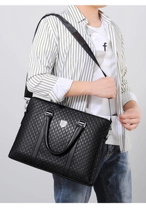 Detail of black embossed leather briefcase with geometric pattern and silver hardware