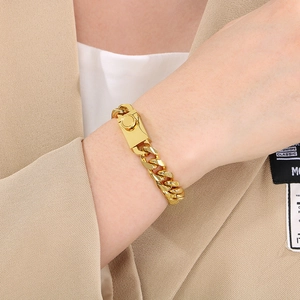 Detail of 10mm golden Miami Cuban link bracelet with rectangle clasp on a wrist