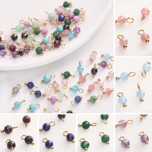 Detailed macro view of multi-colored faceted natural stone pendants with gold metal rings