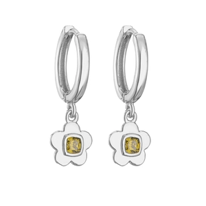 Macro shot of flower hoop earrings with yellow zircon center on silver metal base