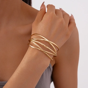 Detail of layered gold geometric bangles featuring a minimalist interlocking circle design