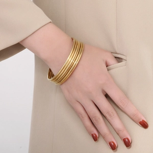 Multi-layer stackable 18k gold plated stainless steel thin bangles worn by a model