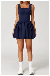 Detail view of navy blue sleeveless tennis dress with a flared bubble skirt hem silhouette