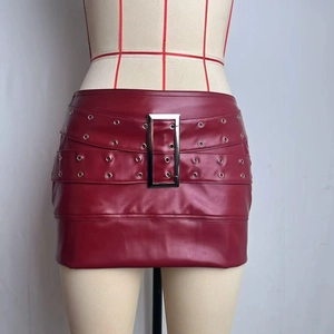 Close-up of burgundy PU leather mini skirt featuring a large metal buckle and eyelet details