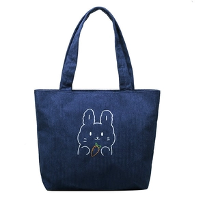 Detail of navy corduroy tote bag with embroidered rabbit holding a carrot design