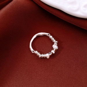 Detail of 18K gold plated beaded ring with pearls on dark red satin fabric