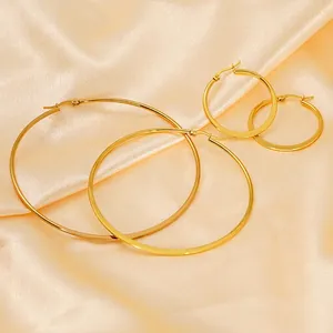 Elegant gold-plated stainless steel hoop earrings set on soft yellow silk fabric