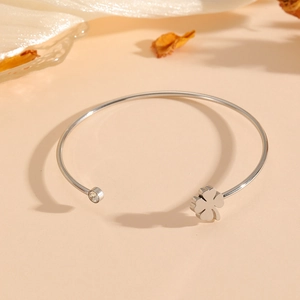 Silver stainless steel open heart flower bangle with zircon on a soft beige background