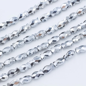Macro shot of silver faceted fish-shaped beads arranged in neat diagonal rows
