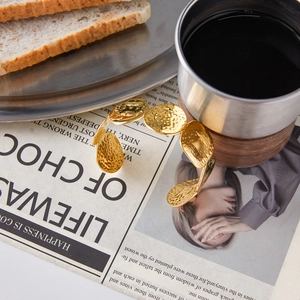 Bracciale rigido aperto in acciaio al titanio martellato da donna color oro lussuoso