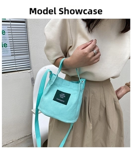 Detailed view of light blue canvas bucket bag with adjustable shoulder strap on model