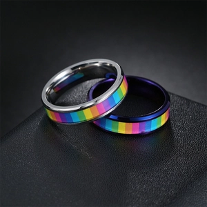 Detail of silver and blue rainbow spinning rings on dark textured leather background