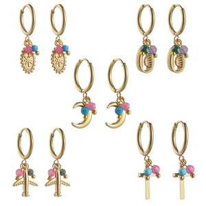 Set of five gold hoop earrings featuring celestial, shell, and airplane charm pendants